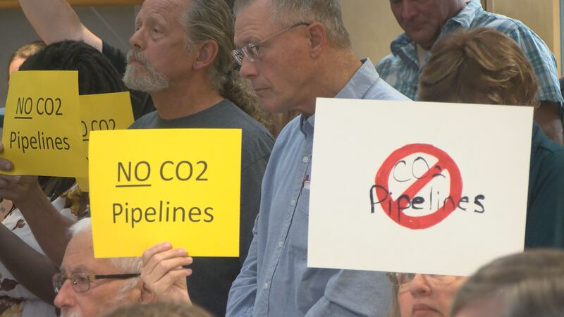 Residents hold up signs protesting a potential CO2 pipeline at the Tazewell County Board...