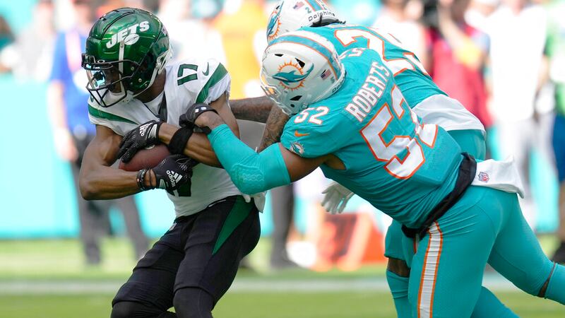 Miami Dolphins linebacker Elandon Roberts (52) grabs New York Jets wide receiver Garrett...