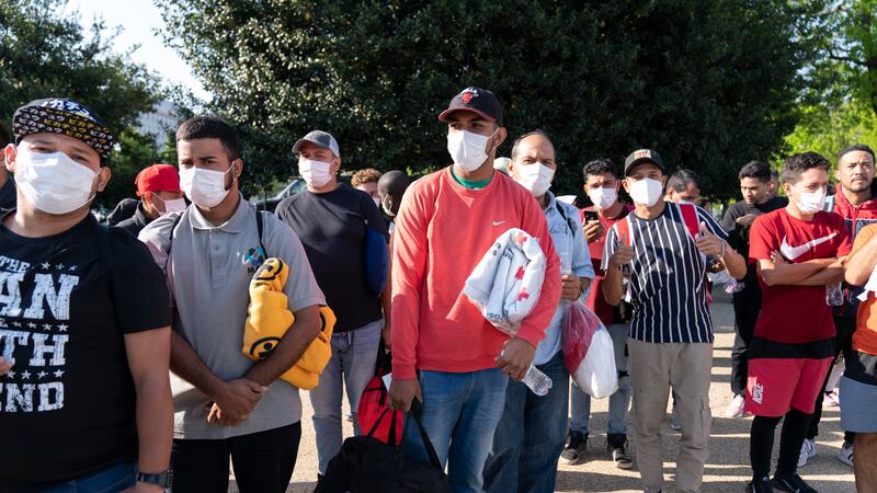 FILE - Migrants hold Red Cross blankets after arriving at Union Station near the U.S. Capitol...